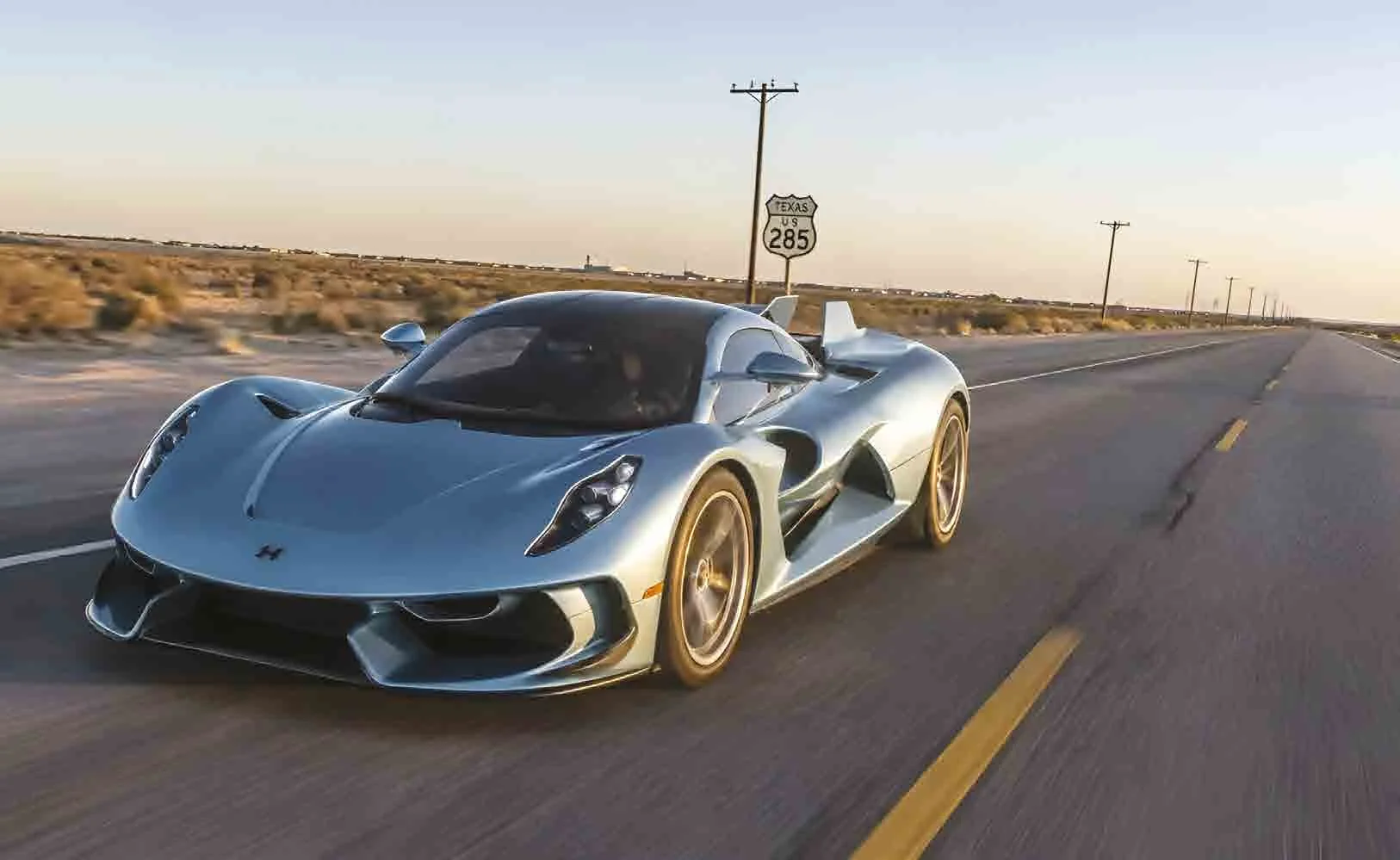 Hennessey Venom F5 plateado en una carretera del desierto